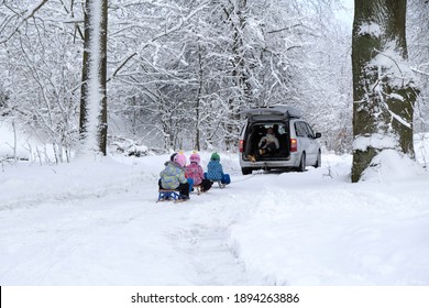 Przywidz, Poland - January 13, 2021: Young Children Go Sledding On A Sleigh Ride With Car Along A Beautiful Snowy Road In The Forest. Przywidz, Kashubia, Poland