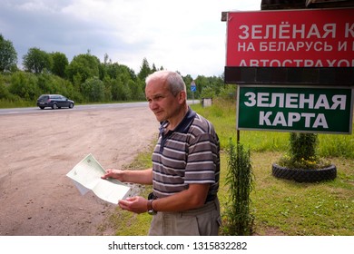 Pskov Region. Russia - July 5, 2018: Point Of Sale Of Green Car Cards And Insurance CTP On The Border With The Republic Of Belarus. Man Examines Insurance Documents.