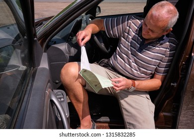 Pskov Region. Russia - July 5, 2018: Point Of Sale Of Green Car Cards And Insurance CTP On The Border With The Republic Of Belarus. Man Examines Insurance Documents.