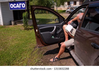 Pskov Region. Russia - July 5, 2018: Point Of Sale Of Green Car Cards And Insurance CTP On The Border With The Republic Of Belarus. Man Examines Insurance Documents.