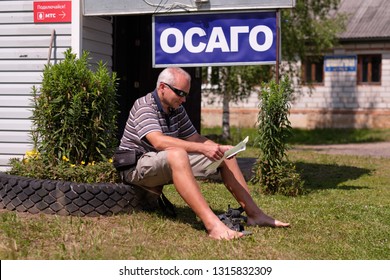 Pskov Region. Russia - July 5, 2018: Point Of Sale Of Green Car Cards And Insurance CTP On The Border With The Republic Of Belarus. Man Examines Insurance Documents.