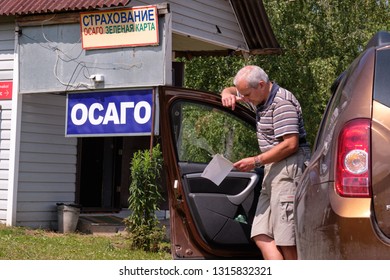 Pskov Region. Russia - July 5, 2018: Point Of Sale Of Green Car Cards And Insurance CTP On The Border With The Republic Of Belarus. Man Examines Insurance Documents.