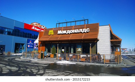 Pskov, Russia - March 24, 2021: McDonald's Fast Food Store In City Center. Brown Colour Facade Of The McCafe. No People Near Building. McDelivery Service. Contact-free Payment. Franchisees. Outdoors.