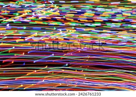 Psychedelic abstract long exposure motion colour lights. Light trails, leaks and glowing electricity. Music visualisation abstraction background. Christmas holiday festive lights.