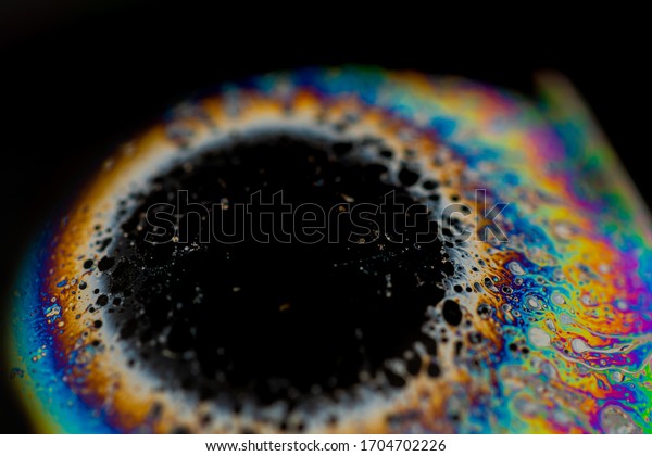 Psychedelic abstract planet shape soap bubble,\
Light refraction on a soap bubble, Macro like iris eye. Rainbow\
colors on a black background. Model of Space or planets universe\
cosmic galaxy
