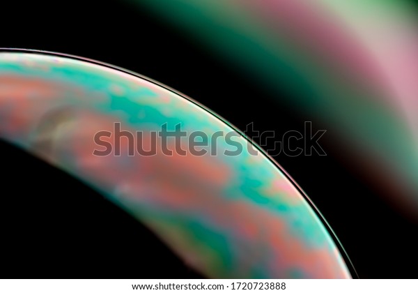Psychedelic abstract planet from soap bubble,
Light refraction on a soap bubble, Macro Close Up moving particles
Rainbow colors on a black background. Model of Space or planets
universe cosmic
galaxy.