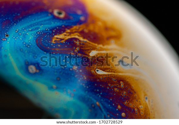 Psychedelic abstract planet-like soap bubble, light\
refraction on a soap bubble, Macro Close Up in soap bubble. Rainbow\
colors on a black background. Model of Space or planets universe\
cosmic. 