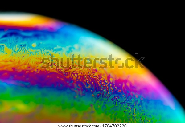 Psychedelic abstract planet-like soap bubble,\
Light refraction on a soap bubble, Macro Close Up in soap bubble.\
Rainbow colors on a black background. Model of Space or planets\
universe cosmic\
galaxy.