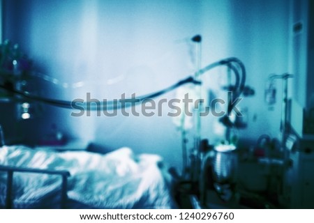 Psychiatric dismal cell (ward) with equipment and a bed. Blurred dark blue medical background.