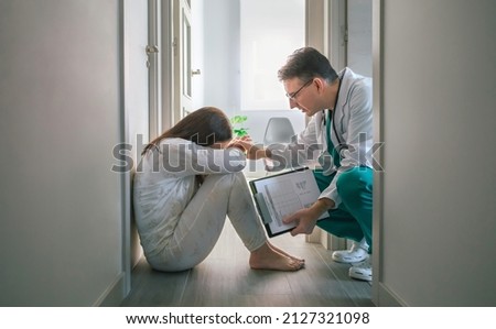 Psychiatrist trying to help with empathy a female patient with mental disorder who refuses help in a mental health center