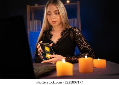 Psychic Tarot card reader on laptop computer while having an online session, copy space