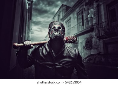 Psycho man in hockey mask with bloody baseball bat
