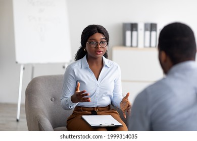 Psychological Counseling. Professional Female Psychotherapist Having Session With Young Black Guy At Office. African American Counselor Giving Advice To Millennial Man At Mental Health Clinic