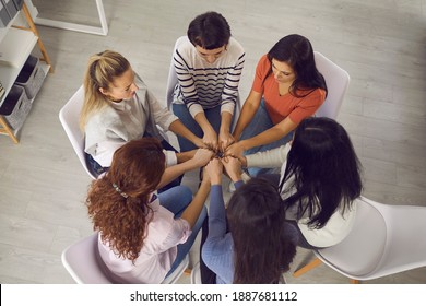 Psychological Help. Coping With Issues And Problems Together. Women Sitting Close In Circle And Holding Hands In Support Group Meeting Or Therapy Session With Psychotherapist. From Above, High Angle