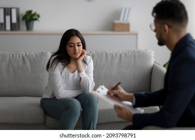 Psychological Help Service. Depressed Arab Woman Having Psychotherapy Session With Counselor, Consulting Professional Therapist At Mental Health Clinic.