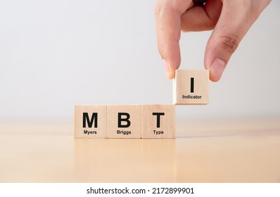 Psychological and personality test concept, Hand puts wooden cubes with MBTI, Myers-Briggs Type Indicator on table. - Shutterstock ID 2172899901