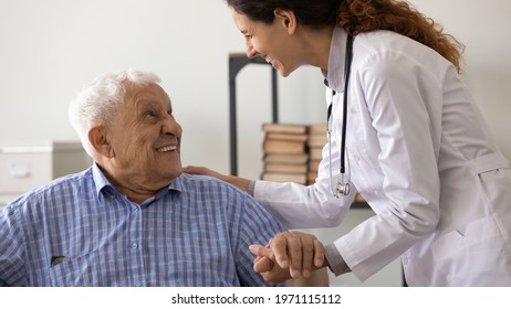 Psychological Support. Friendly Medical Worker Caregiver Help Assist Older Male With Hard Diagnosis. Smiling Female Doctor Talk With Old Man Patient Express Empathy Share Positive Emotions Hold Hand