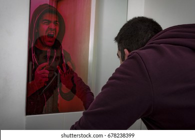 Psychological torment by your own demons and mental illness concept with a man looking in the mirror and seeing his own reflection as a demon holding a bloody razor telling him to harm or kill himself - Shutterstock ID 678238399