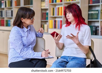 Psychologist, College Counselor Counseling Teenage Student In Library, Office
