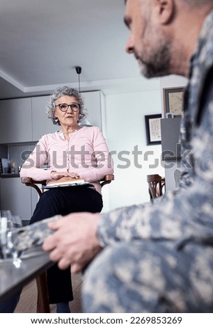 Psychologist having therapy meeting with male soldier.