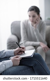 Psychologist listening to her patient and writing down notes, mental health and counseling concept