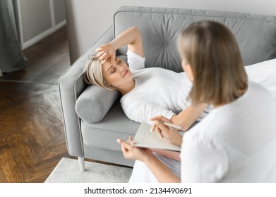 Psychologist Session. A Young Woman In Therapy With An Old Woman Psychologist.
Lying On The Couch And Very Worried About The Situation.