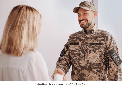 Psychologist shaking hands with military officer in office - Powered by Shutterstock