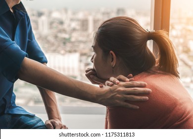 Psychologist Sitting And Touch Young Depressed Asian Woman For Encouragement Near Window With Low Light Environment, Selective Focus, PTSD Mental Health Concept,