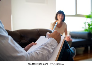 Psychologist taking notes during therapy session. - Shutterstock ID 1931601869