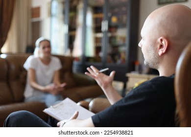 Psychologist is talking to patient while sitting on chair in office during psychotherapy session. Mental health, support and therapy concept. - Shutterstock ID 2254938821