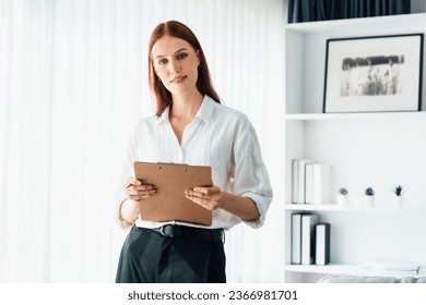 Psychologist woman in clinic office professional portrait with friendly smile feeling inviting for patient to visit the psychologist. The experienced and confident psychologist is utmost specialist - Shutterstock ID 2366981701
