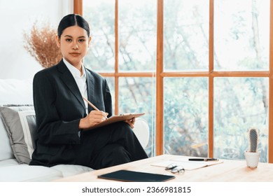 Psychologist woman in clinic office professional portrait with friendly smile feeling inviting for patient to visit the psychologist. The experienced and confident psychologist is uttermost specialist - Shutterstock ID 2366981815