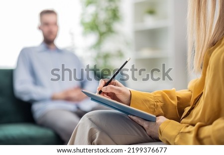 Psychologist woman doctor making notes consulting male patient in bright office, healthcare concept, hands section