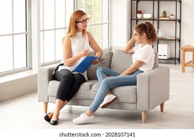 Psychologist working with teenage girl in office - Shutterstock ID 2028107141