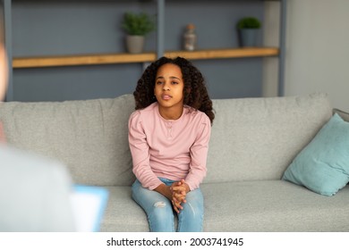 Psychologist working with upset african american girl in office, sad teenager patient talking about her feelings, problems and trauma to psychotherapist, sitting on couch
