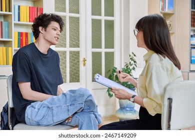 Psychologist working with young male college student in educational office - Powered by Shutterstock