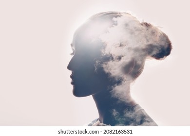 Psychology and caucasian woman mental health concept. Multiple exposure clouds and sun on female head silhouette.