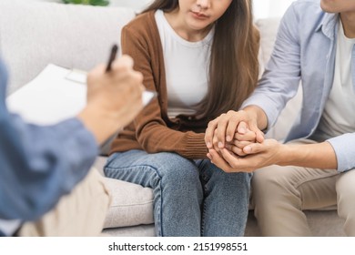 Psychology, depression asian young couple, patient consulting problem mental health with psychologist, psychiatrist at clinic together, husband encouraging by holding hand of wife, therapy health care - Powered by Shutterstock