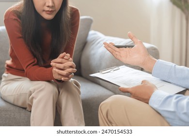 Psychology, depression. Sad asian young woman consultation with psychologist while patient counseling mental therapy, doctor hand taking notes at clinic. Psychologist with sick mental health person. - Powered by Shutterstock