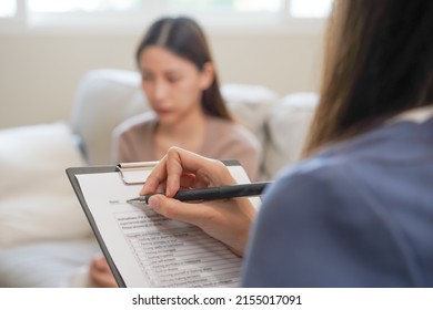 Psychology, depression. Sad, suffering asian young woman consulting with psychologist, psychiatrist while patient counseling mental with doctor woman taking notes at clinic. Encouraging, therapy. - Shutterstock ID 2155017091