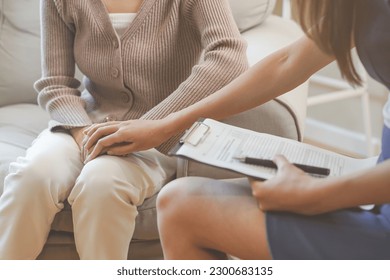 Psychology, depression. Sad, suffering asian young woman, consulting with psychologist, psychiatrist while patient counseling mental problem with doctor at clinic. Encouraging, therapy, health care. - Shutterstock ID 2300683135