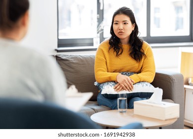psychology and mental therapy concept - young asian woman patient and psychologist at psychotherapy session