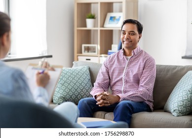 Psychology, Mental Therapy And People Concept - Happy Smiling Young Indian Man Patient And Woman Psychologist At Psychotherapy Session