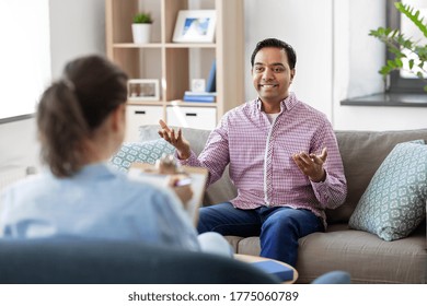 Psychology, Mental Therapy And People Concept - Happy Smiling Young Indian Man Patient And Woman Psychologist At Psychotherapy Session