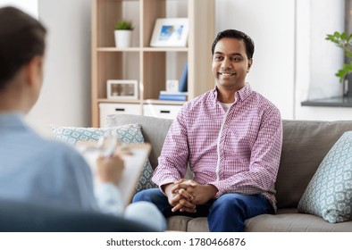 Psychology, Mental Therapy And People Concept - Happy Smiling Young Indian Man Patient And Woman Psychologist At Psychotherapy Session