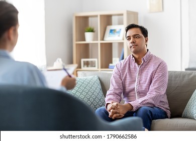 psychology, mental therapy and people concept - young indian man patient and woman psychologist at psychotherapy session