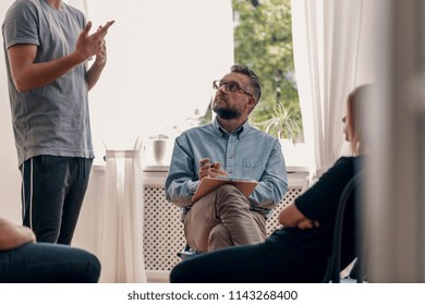 Psychotherapist Listening To His Patient's Confession During Group Therapy