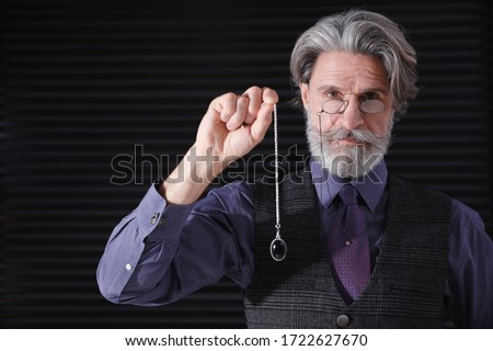 Psychotherapist with pendulum on black background. Hypnotherapy session