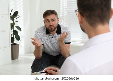 Psychotherapist working with drug addicted young man indoors - Shutterstock ID 2020666316