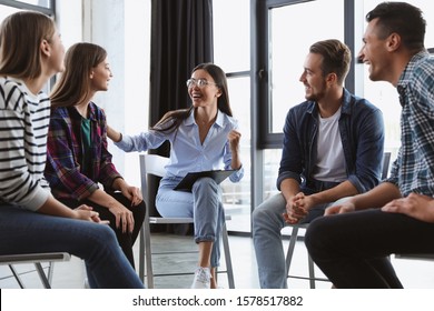 Psychotherapist working with patients in group therapy session indoors - Shutterstock ID 1578517882